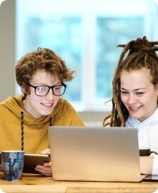 two young people looking at a laptop